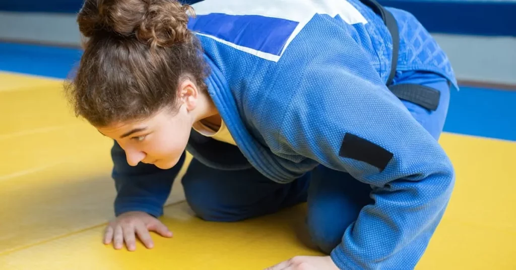 Student practicing basic self defense skills and body control during martial arts floor training.