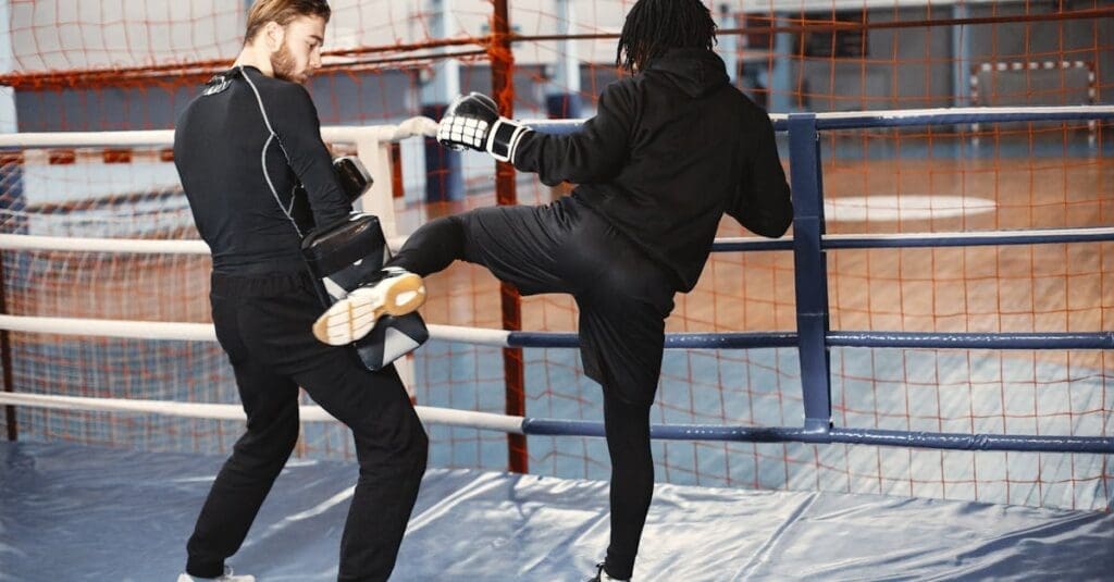 An instructor holding a kick pad while a student practices a side kick in a boxing ring during self defense training for beginners.